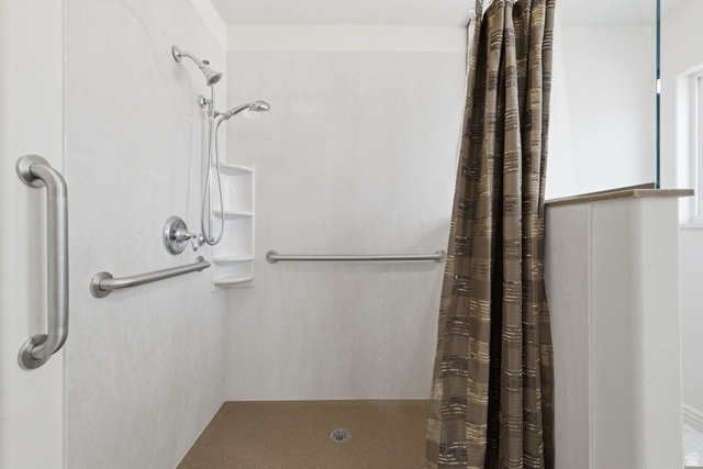805 South River Road, Unit 70 St. George, UT 84790 - Photo 19 of 38 Walk-in shower with a neutral-toned floor, white paneling, and brushed nickel grab bars