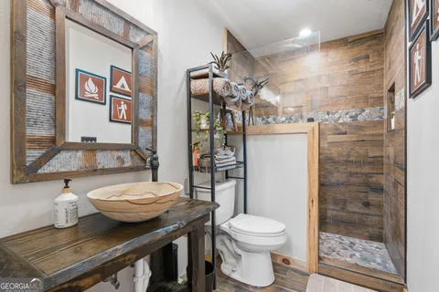 a bathroom with a granite countertop toilet a sink and a shower