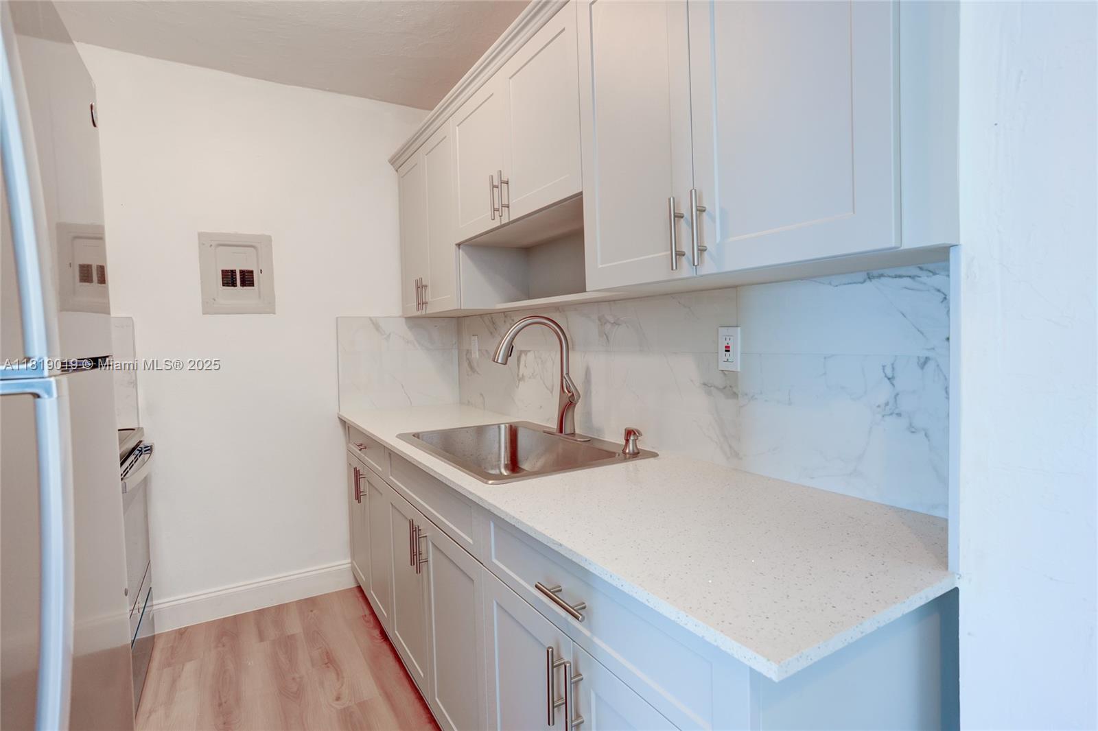 5501 Northwest 7th Street, Unit E408 Miami, FL 33126 - Photo 13 of 35 a kitchen with a sink and cabinets