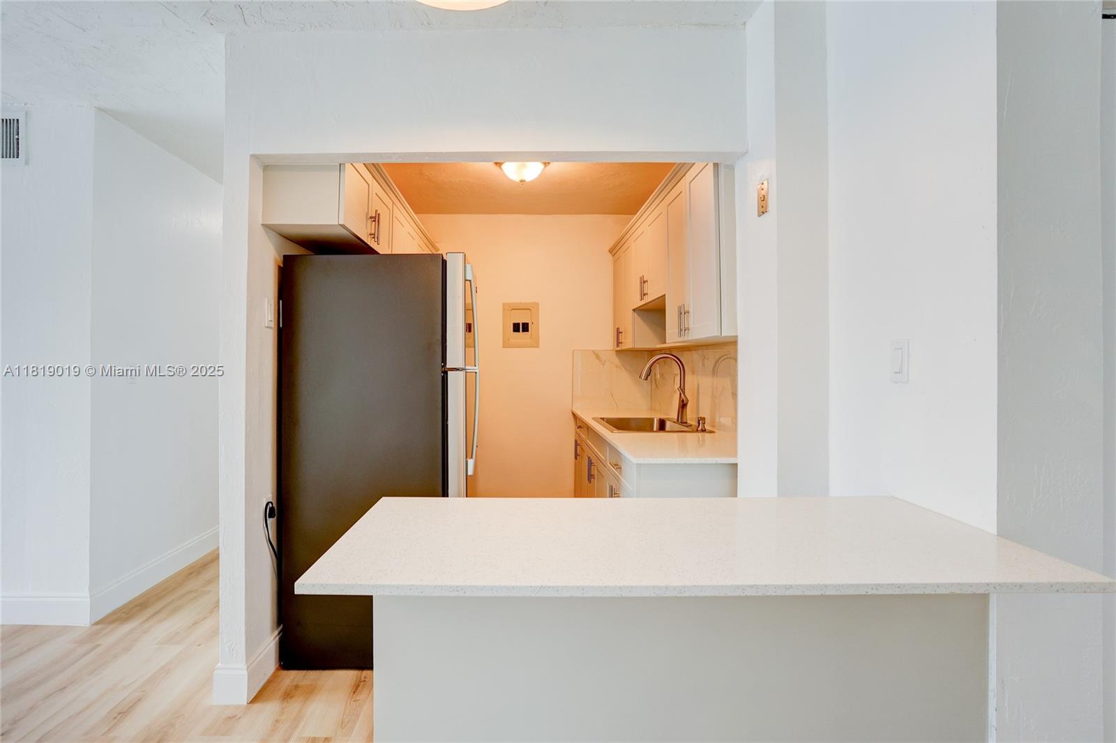 5501 Northwest 7th Street, Unit E408 Miami, FL 33126 - Photo 14 of 35 a room with a refrigerator and mirror