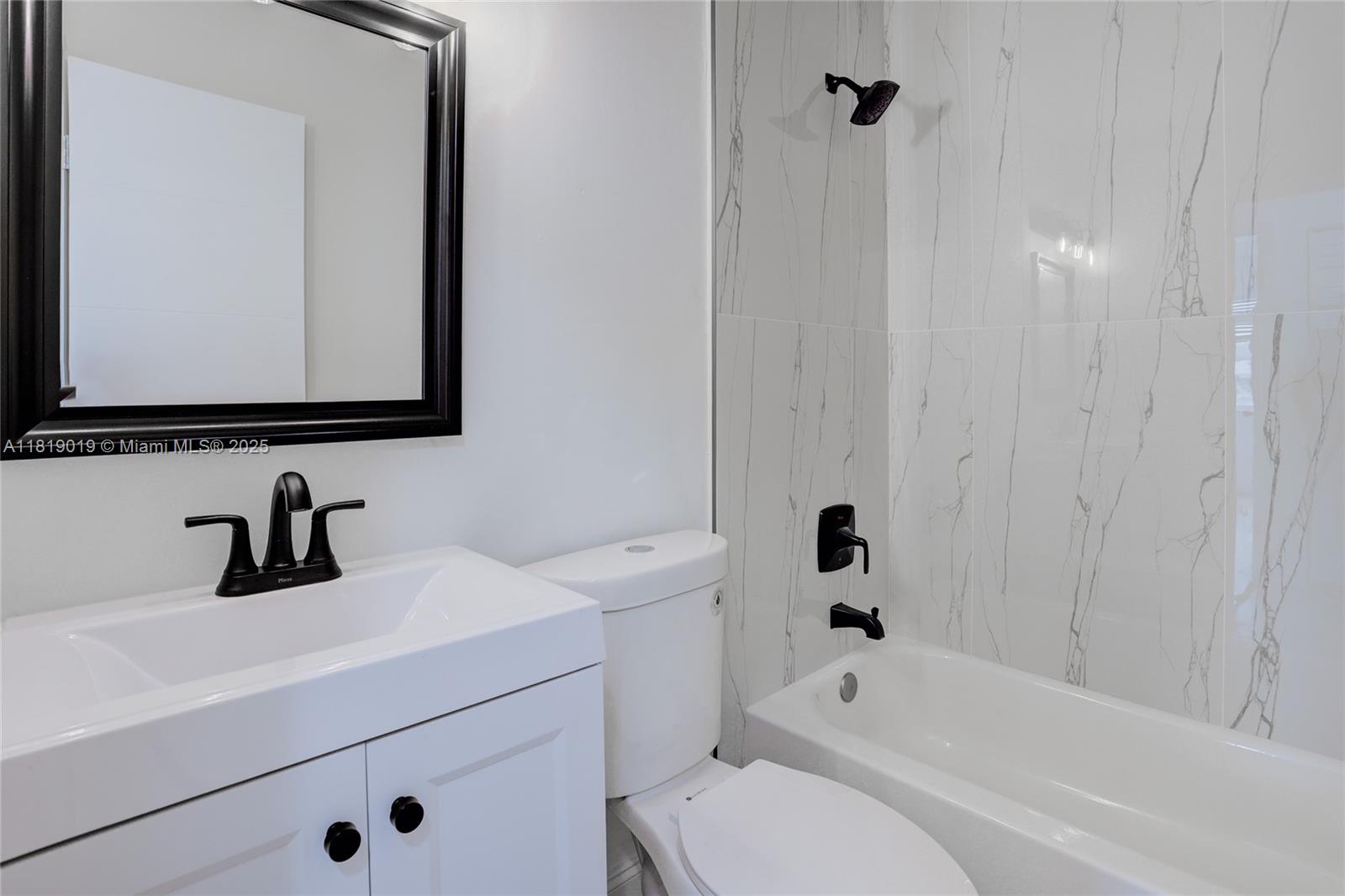 5501 Northwest 7th Street, Unit E408 Miami, FL 33126 - Photo 24 of 35 a bathroom with a sink a toilet and shower