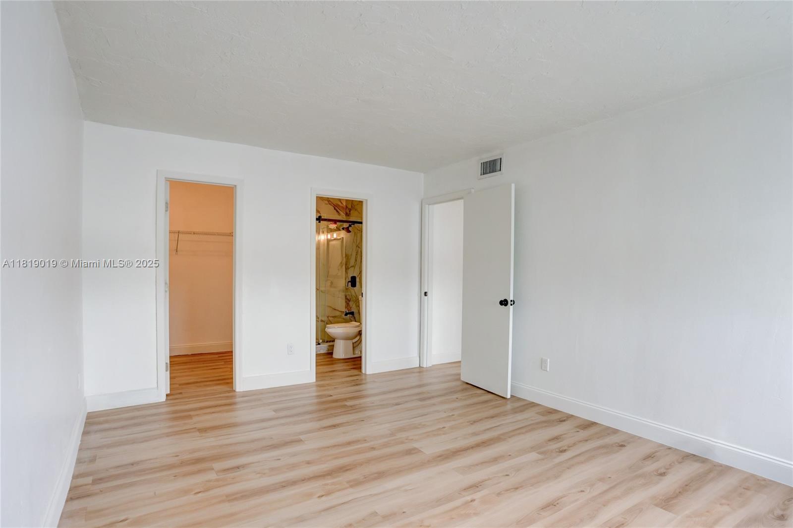 5501 Northwest 7th Street, Unit E408 Miami, FL 33126 - Photo 28 of 35 a view of an empty room with wooden floor and closet