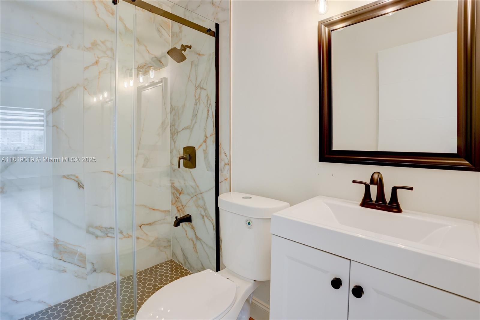 5501 Northwest 7th Street, Unit E408 Miami, FL 33126 - Photo 29 of 35 a bathroom with a sink a toilet and shower