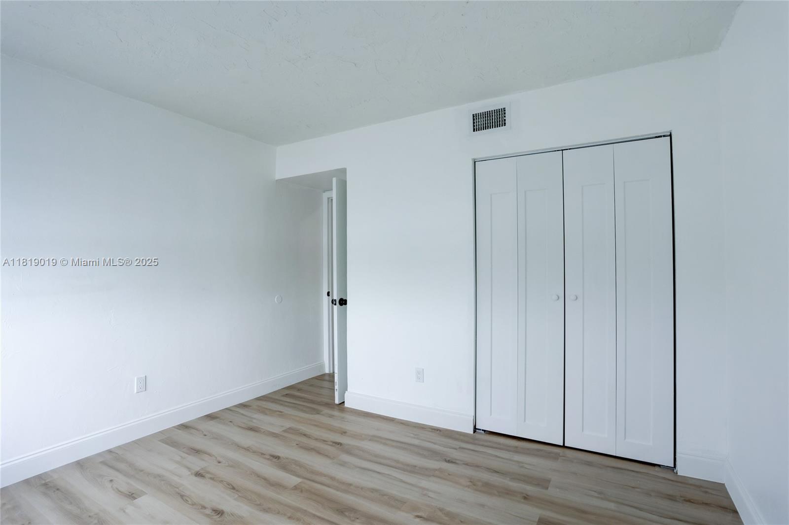 5501 Northwest 7th Street, Unit E408 Miami, FL 33126 - Photo 30 of 35 a view of an empty room with wooden floor