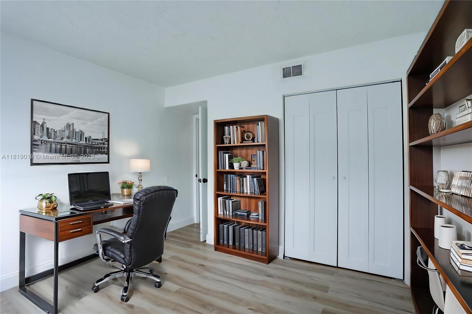 5501 Northwest 7th Street, Unit E408 Miami, FL 33126 - Photo 31 of 35 a view of a workspace with bookshelf and a workspace
