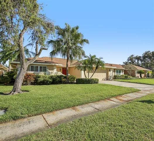 a front view of a house with a yard and potted plants
