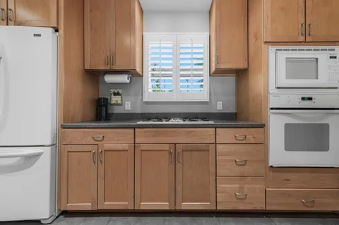a kitchen with granite countertop cabinets stainless steel appliances and a sink