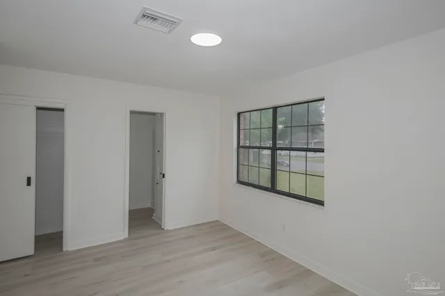 a view of empty room with wooden floor