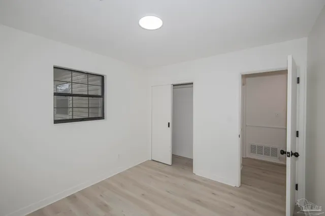 an empty room with wooden floor and cabinet