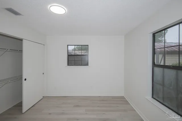 a view of a brick house next to a yard with potted plants