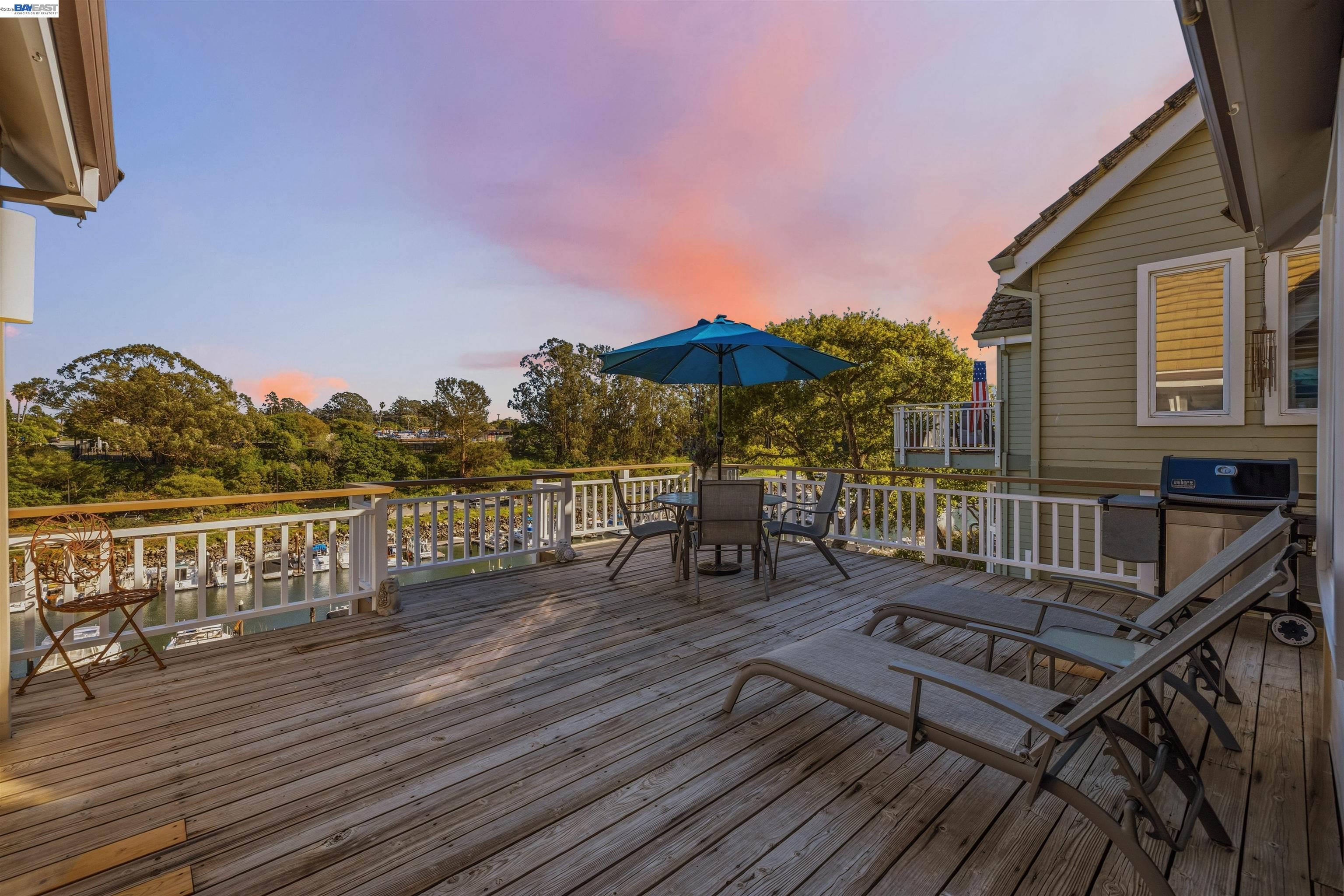 126 Frederick Street Santa Cruz, CA 95062 - Photo 44 of 60 a view of a roof deck with table and chairs with wooden floor and fence