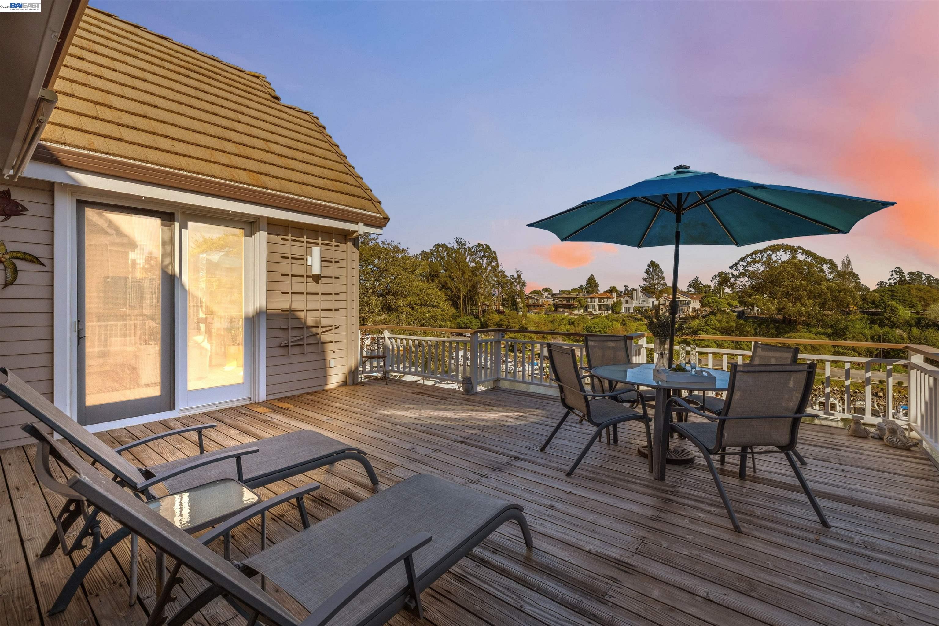 126 Frederick Street Santa Cruz, CA 95062 - Photo 46 of 60 a view of a roof deck with table and chairs under an umbrella with wooden floor