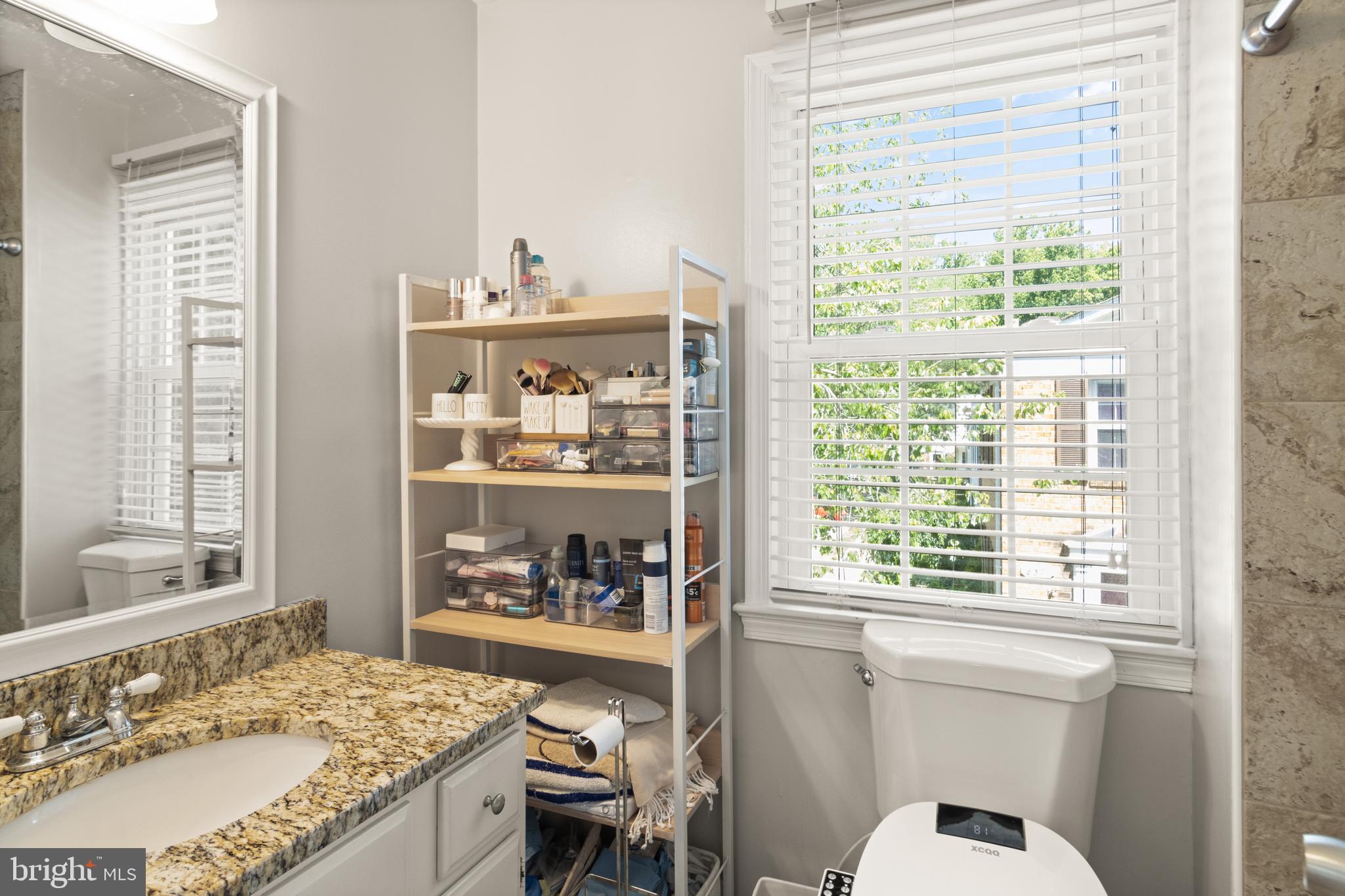 8573 Tyrolean Way Springfield, VA 22153 - Photo 16 of 32 a bathroom with a granite countertop sink mirror and a window