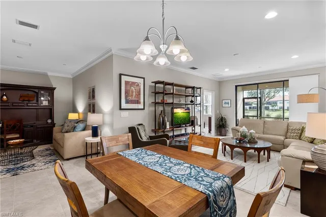 a living room with furniture a chandelier and a flat screen tv