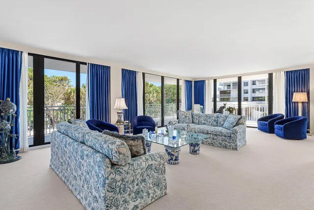 a living room with furniture and large windows
