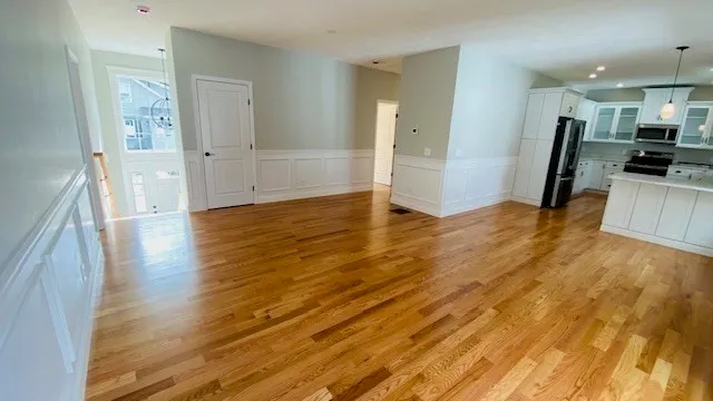 a view of a living room hardwood floor and a kitchen