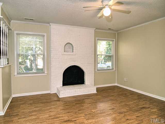 308 Sawmill Road Raleigh, NC 27615 - Photo 4 of 15 a view of a livingroom with a fireplace a ceiling fan and windows