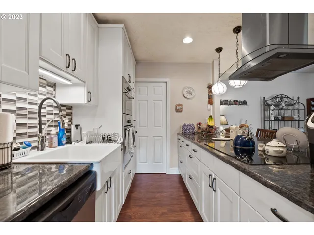 a large kitchen with stainless steel appliances kitchen island granite countertop a sink and cabinets