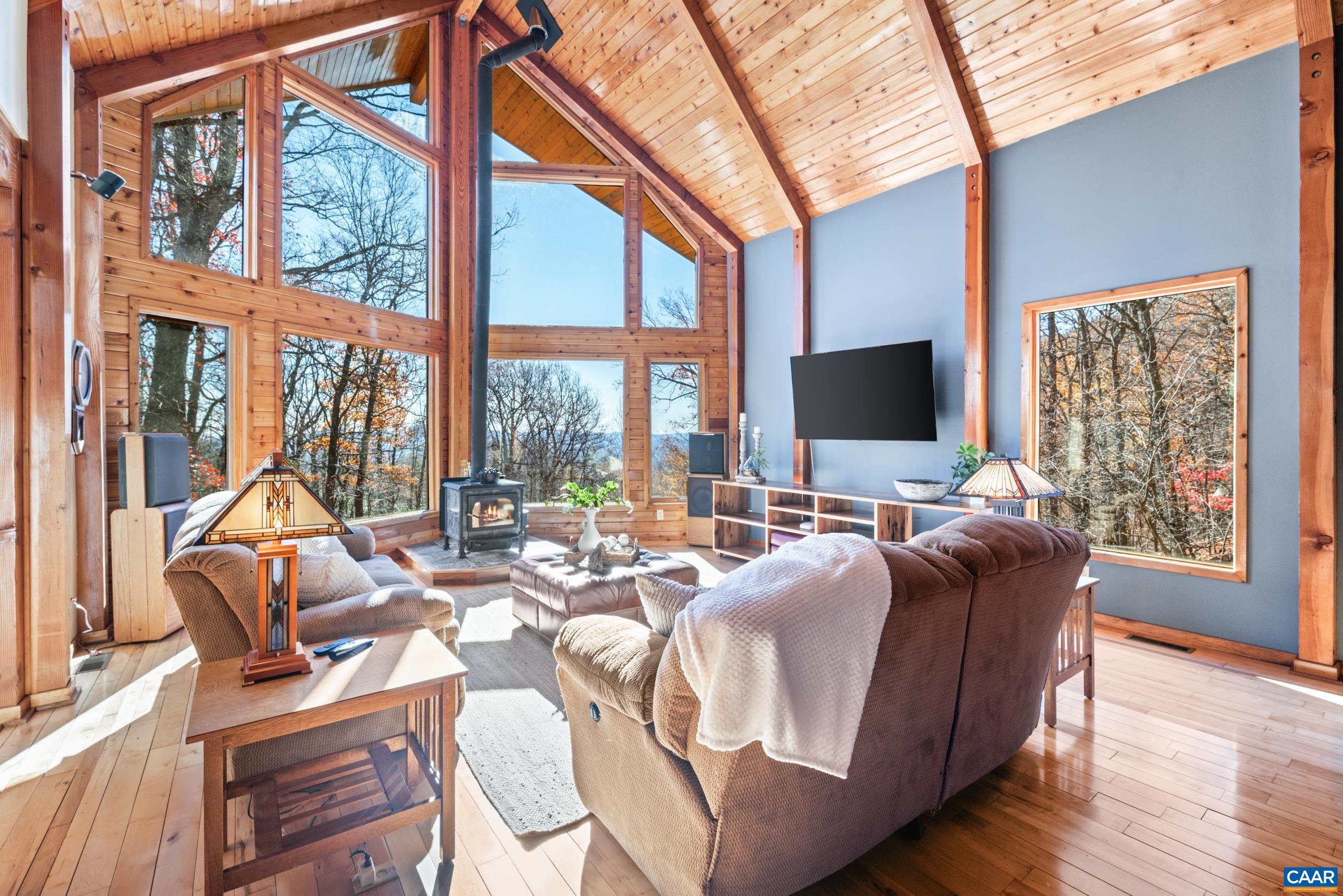 6696 Highlander Way Crozet, VA 22932 - Photo 16 of 71 a living room with furniture tv and large windows