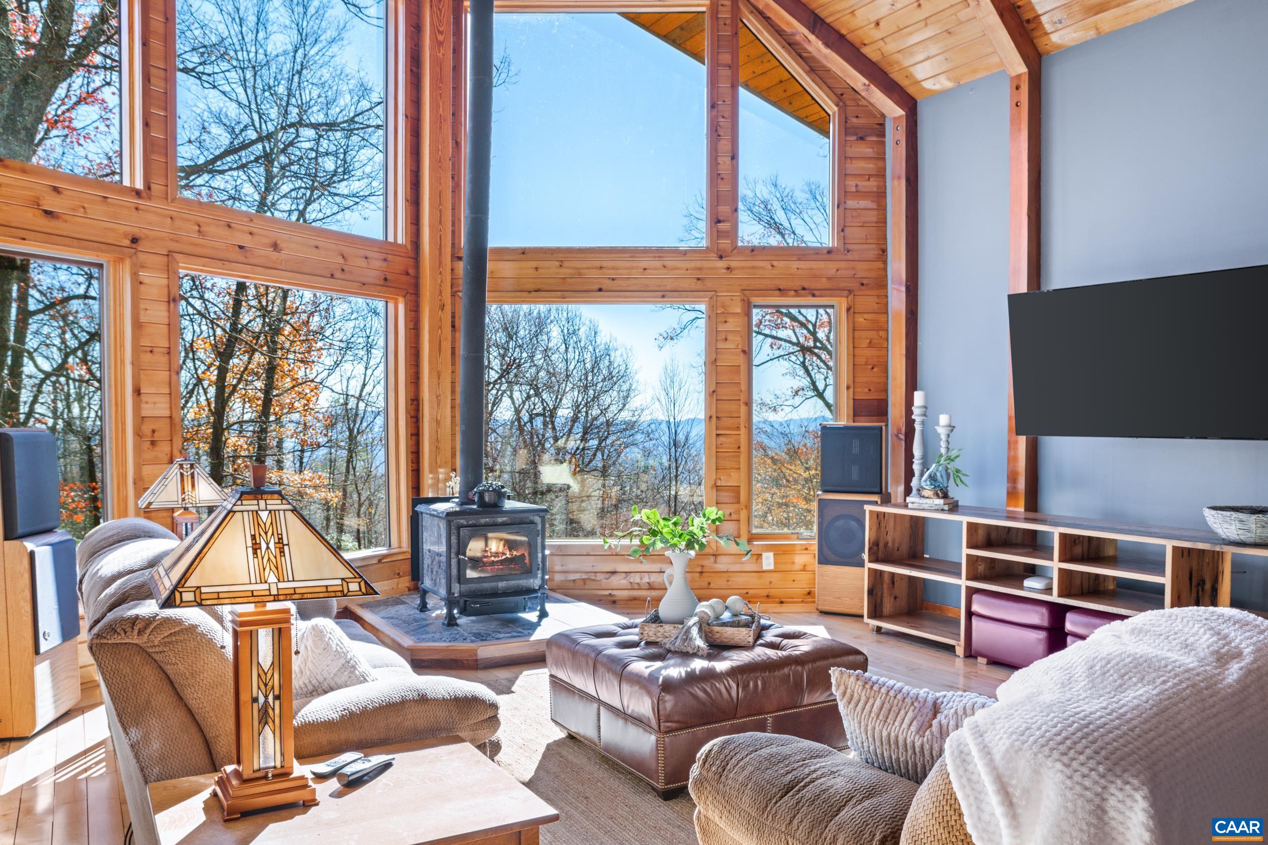 6696 Highlander Way Crozet, VA 22932 - Photo 17 of 71 a living room with furniture a floor to ceiling window and a flat screen tv