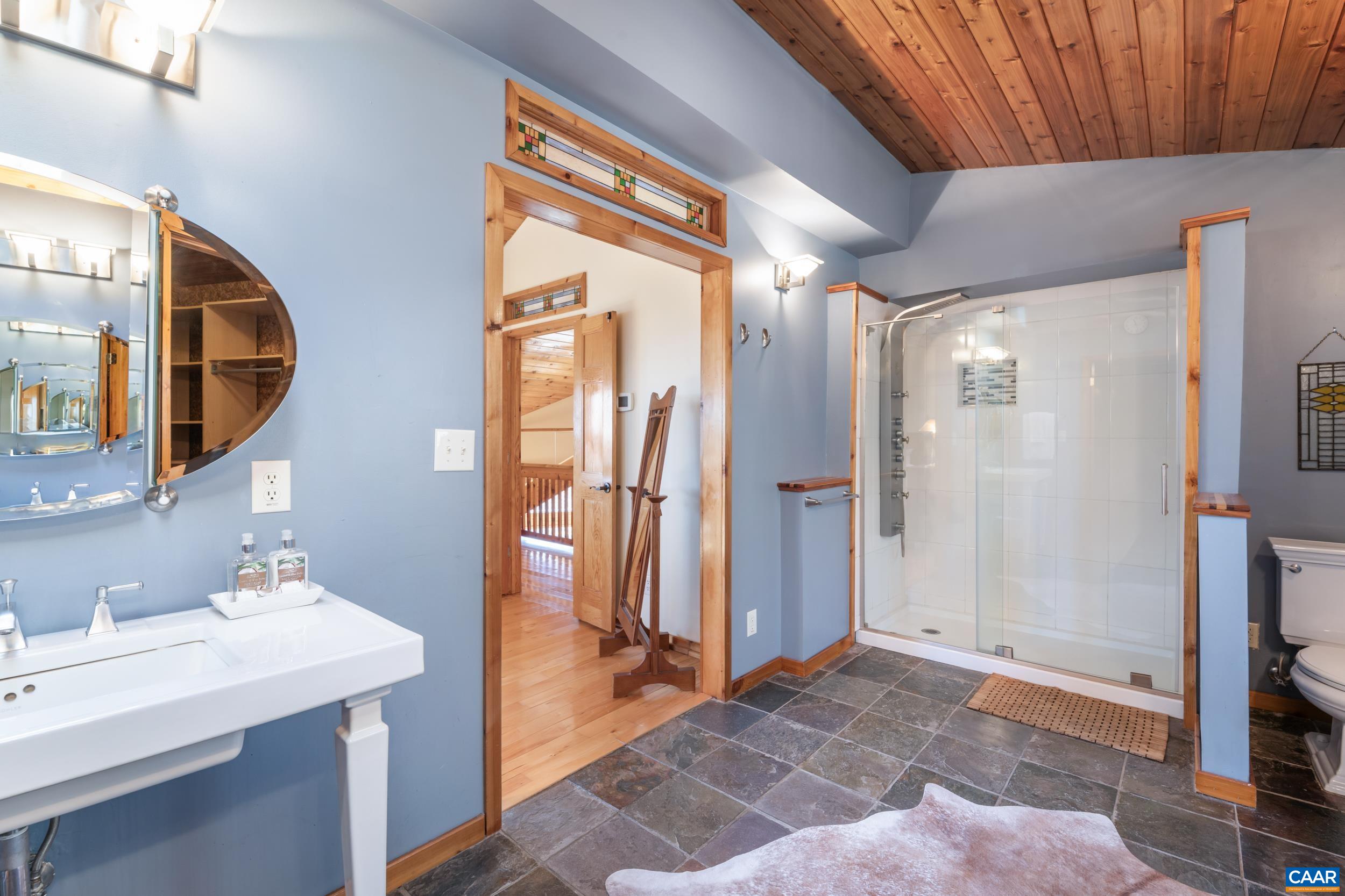 6696 Highlander Way Crozet, VA 22932 - Photo 39 of 71 a spacious bathroom with a mirror a sink and glass door shower