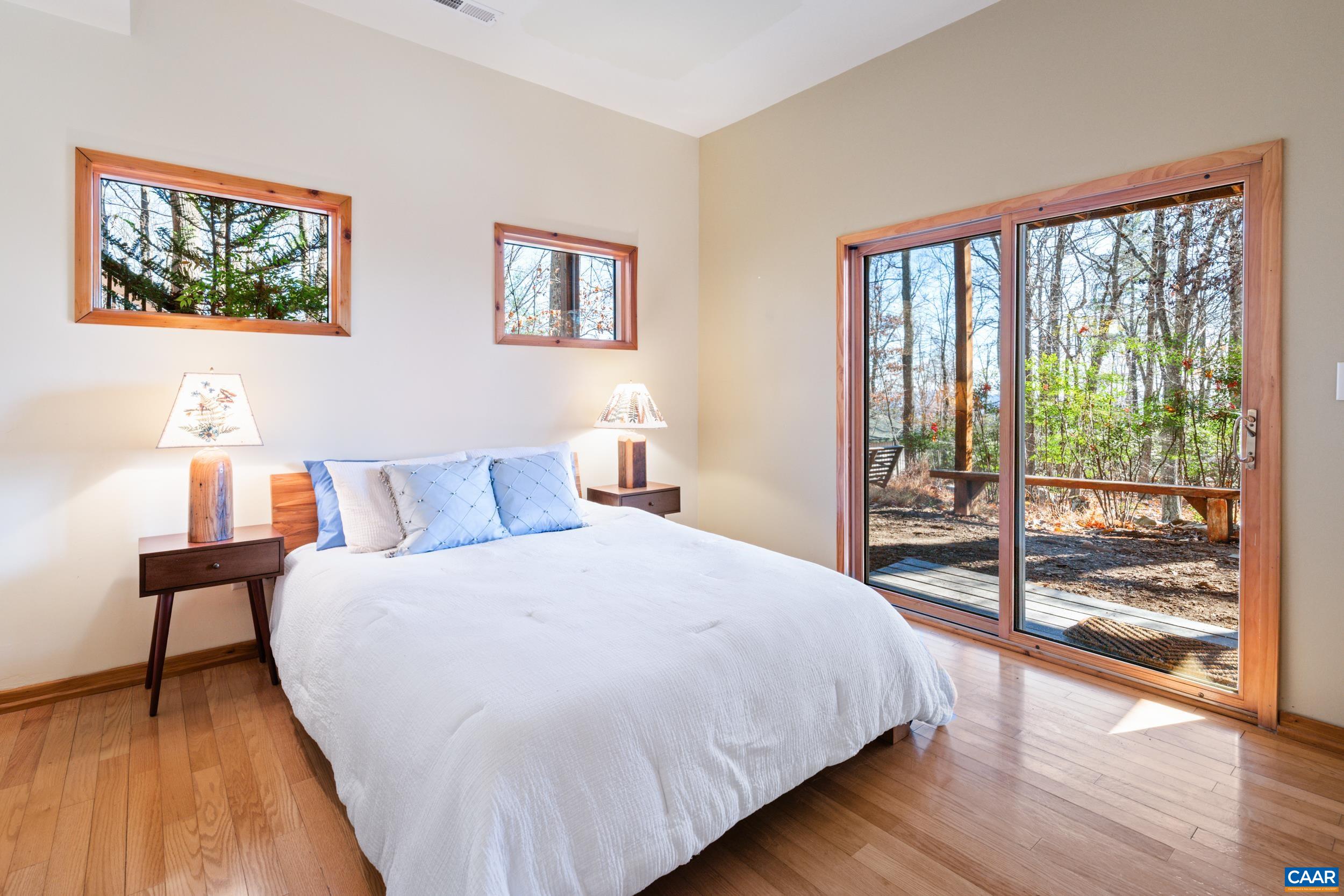 6696 Highlander Way Crozet, VA 22932 - Photo 43 of 71 a bedroom with a large bed and a lamp next to a window