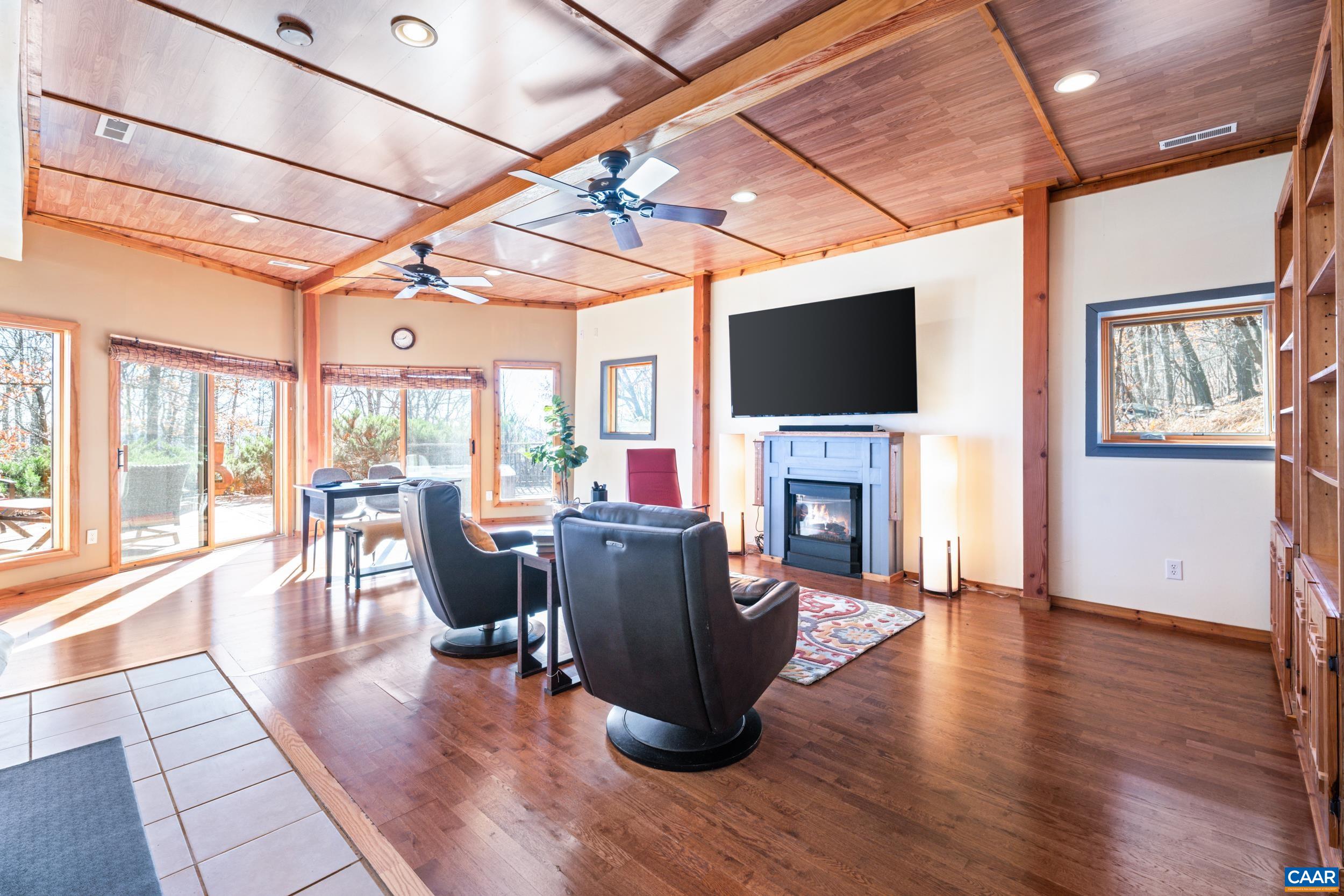 6696 Highlander Way Crozet, VA 22932 - Photo 49 of 71 a living room with fireplace furniture flat screen tv and wooden floor