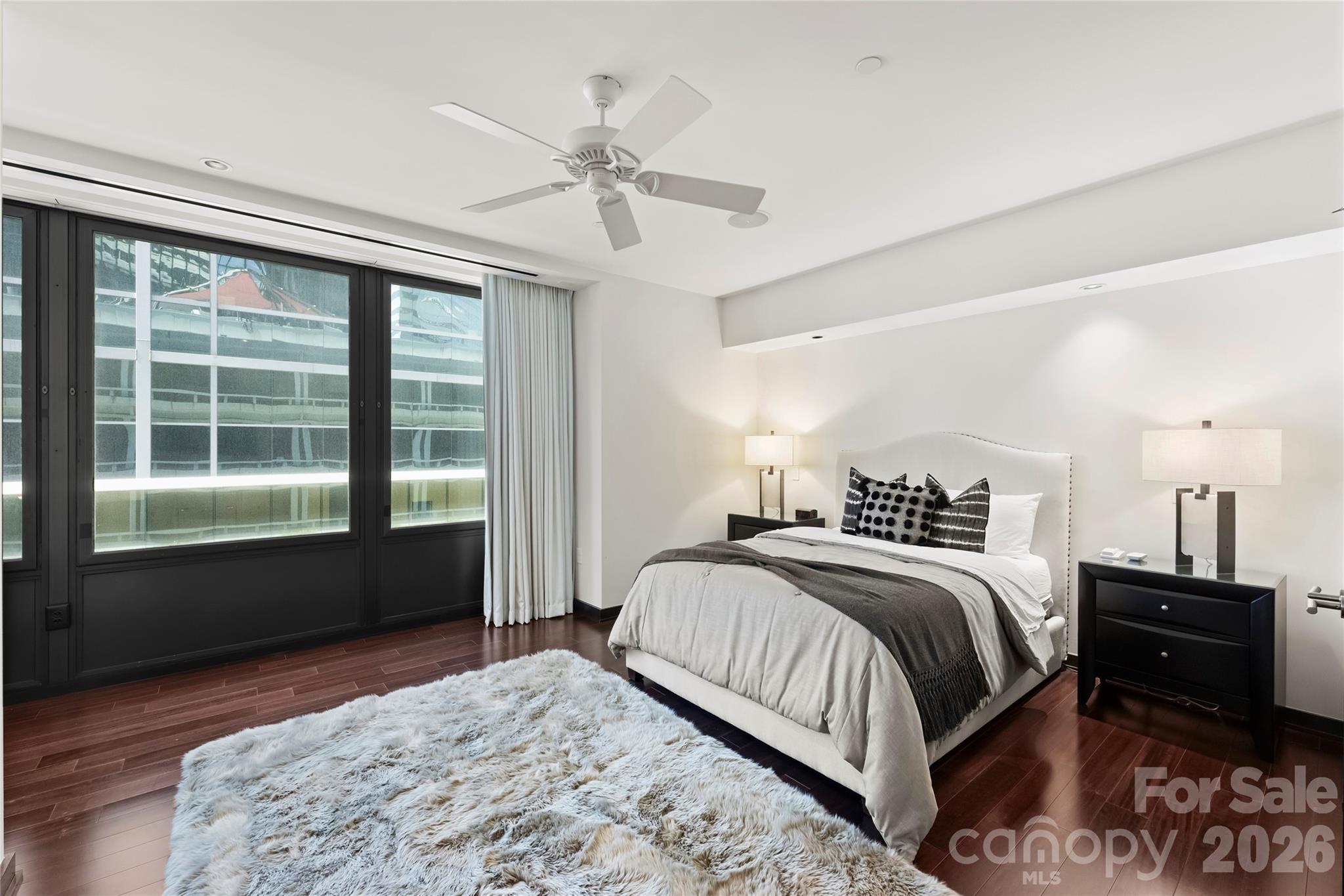 139 South Tryon Street, Unit 6 Charlotte, NC 28202 - Photo 39 of 47 a bedroom with a bed and wooden floor