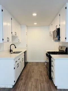a kitchen with a sink a stove and cabinets