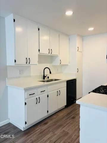 a kitchen with granite countertop a sink a stove and cabinets
