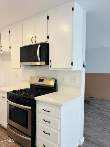 a kitchen with granite countertop a stove and a microwave