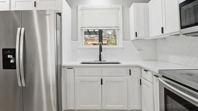 a kitchen with white cabinets and a refrigerator