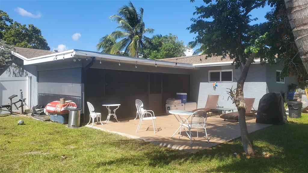 616 Southeast 8th Avenue Deerfield Beach, FL 33441 - Photo 33 of 38 a view of a patio with table and chairs potted plants and a large tree