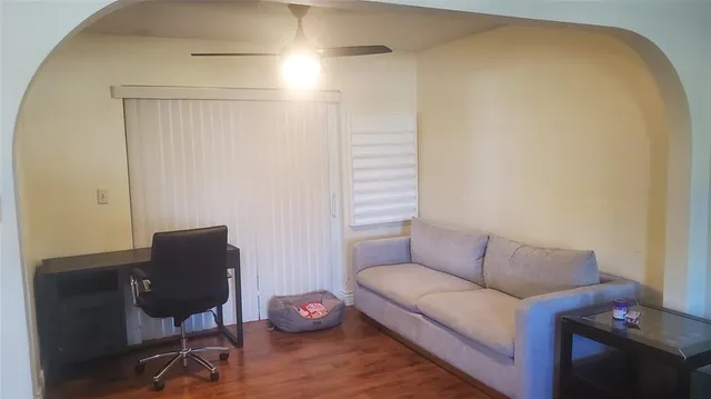 a living room with furniture and a wooden floor