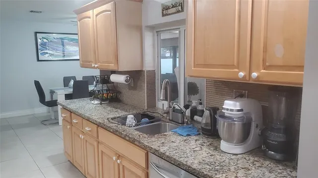 a kitchen with a granite countertop sink and cabinets