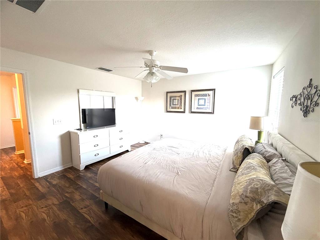 4573 Ada Lane Kissimmee, FL 34746 - Photo 21 of 37 a bedroom with a bed and a flat screen tv