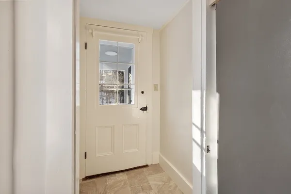 a view of a hallway with wooden floor and a window