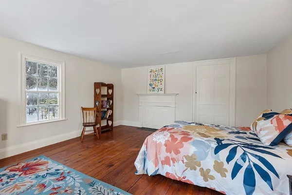 a large bedroom with a bed and wooden floor