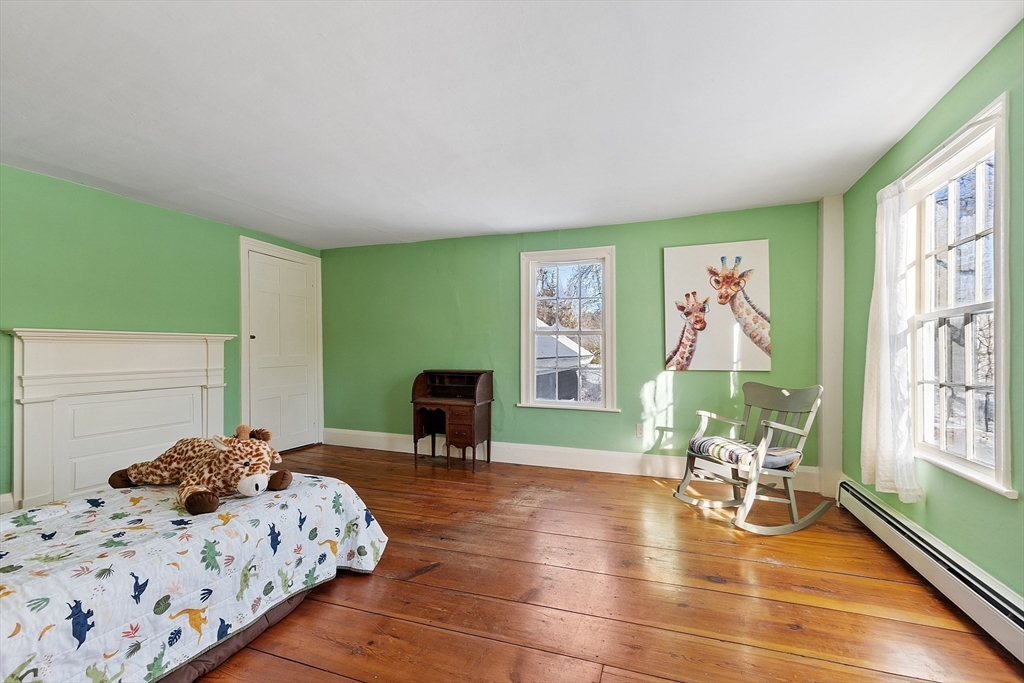 25 Bulkeley Road, Unit CENTER Littleton, MA 01460 - Photo 24 of 40 a bed room with a bed and a chair