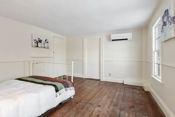 a large bedroom with a bed and wooden floor