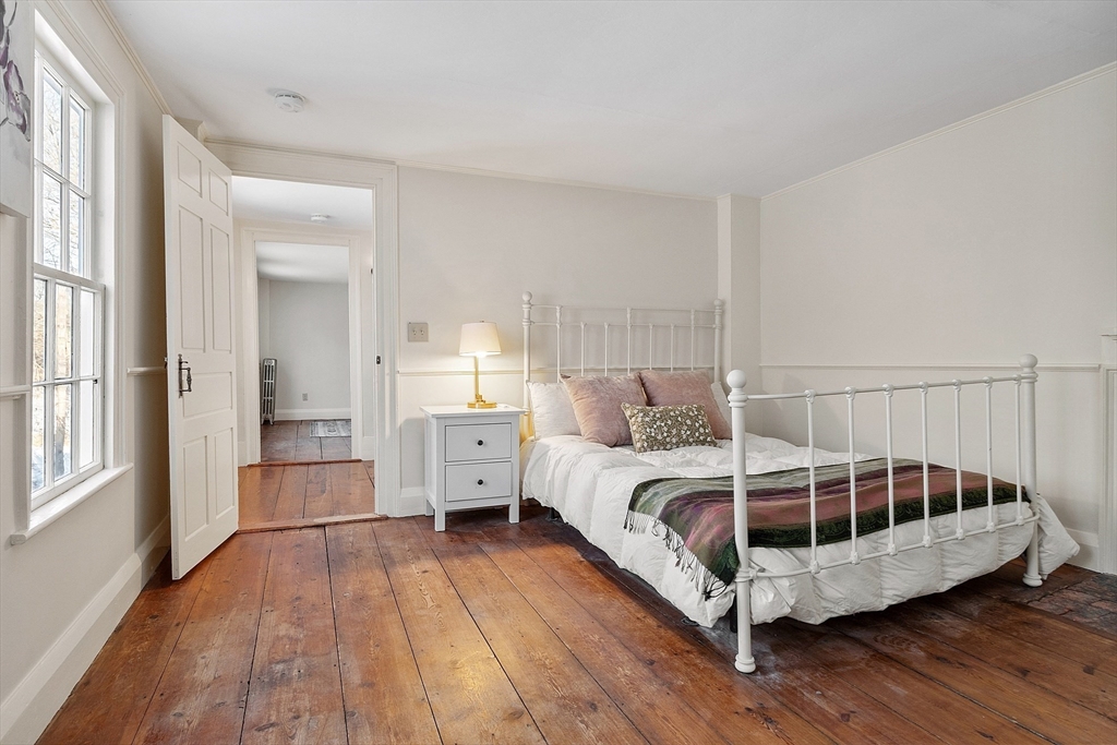 25 Bulkeley Road, Unit CENTER Littleton, MA 01460 - Photo 31 of 40 a large bedroom with a bed and wooden floor