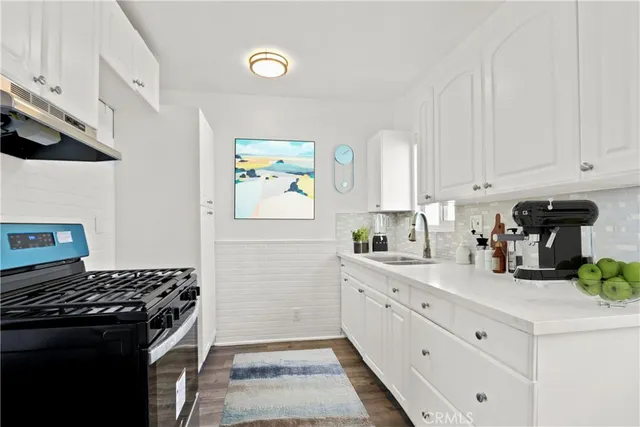 a kitchen with stainless steel appliances a stove a sink and a refrigerator