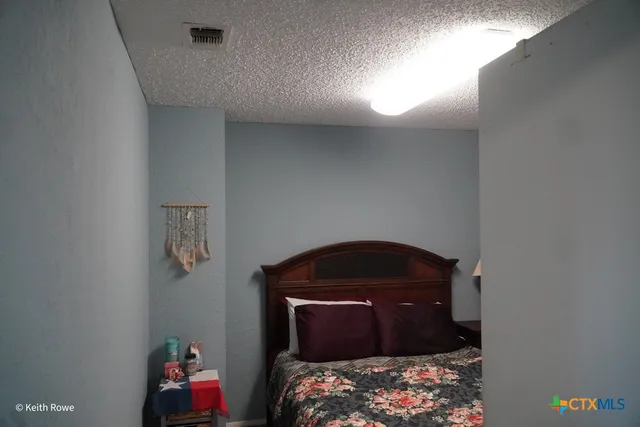 a view of an empty room with wooden floor and closet