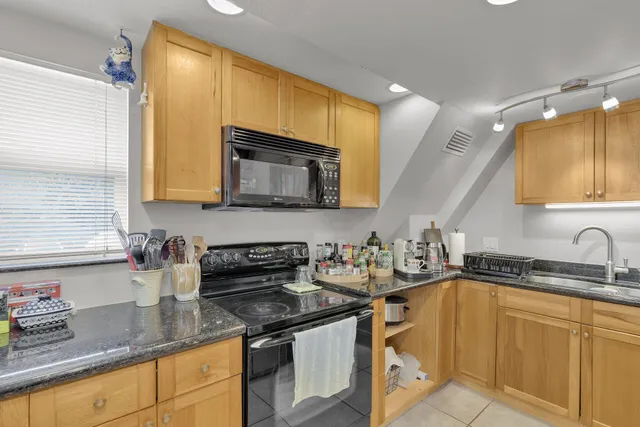 a kitchen with stainless steel appliances granite countertop a sink a stove a microwave a counter space and cabinets