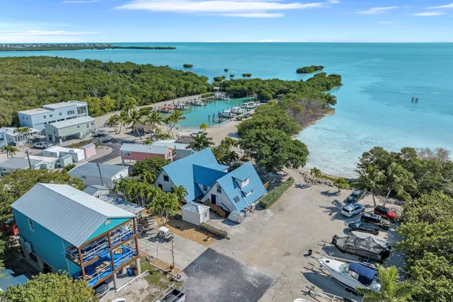 an aerial view of ocean and residential houses with outdoor space