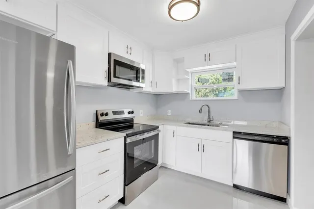 a kitchen with stainless steel appliances granite countertop a refrigerator sink and stove