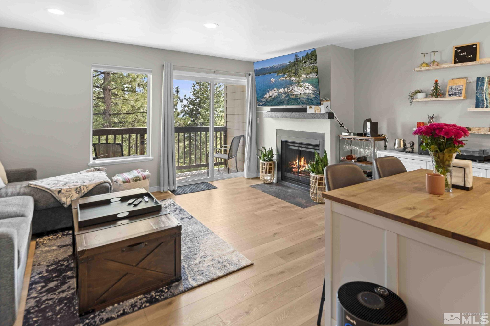 115 Tramway Drive, Unit 2 Stateline, NV 89449 - Photo 3 of 22 a living room with furniture a fireplace and a floor to ceiling window