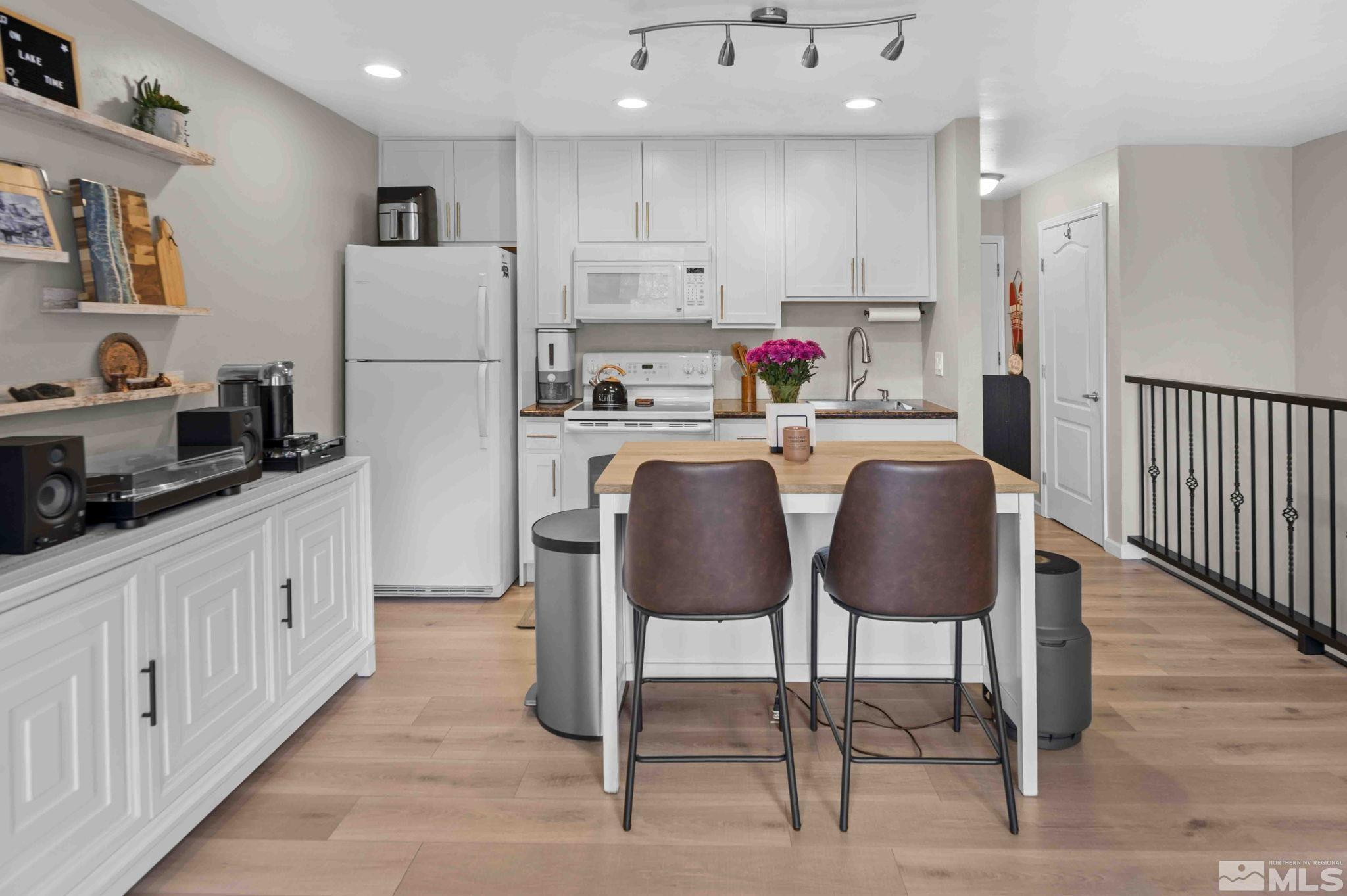 115 Tramway Drive, Unit 2 Stateline, NV 89449 - Photo 4 of 22 a kitchen with kitchen island wooden cabinets stainless steel appliances and dining table