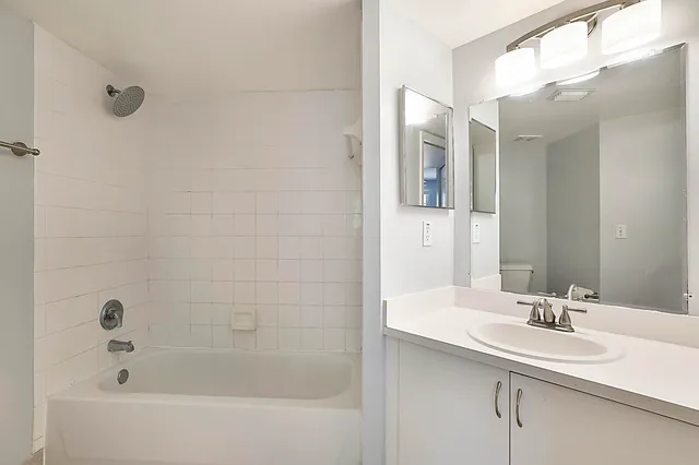 a bathroom with a tub sink and mirror