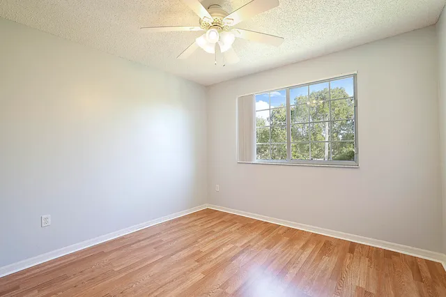 an empty room with a window and wooden floor